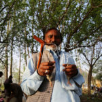 A man is holding his birds, Swabi, KP, March 19, 2017